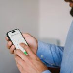 a man types in the whg phone number on his mobile phone dialler